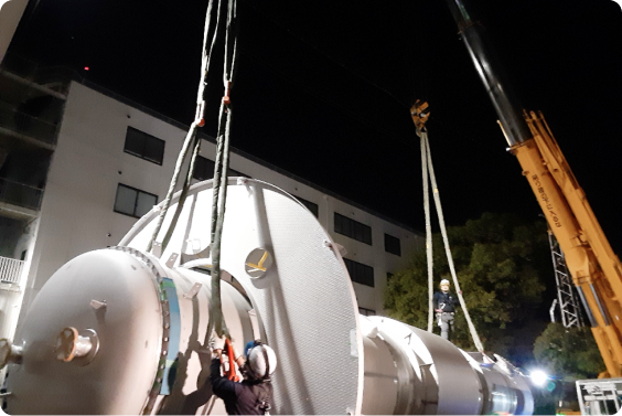 クレーンで大型のタンクを吊り上げている様子